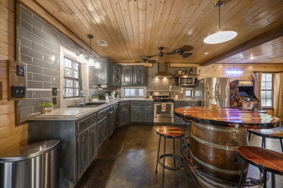 Well-stocked kitchen with custom concrete countertops and distressed cabinets