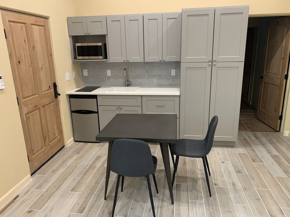 Kitchenette with table  
Plentiful cabinets, microwave, mini-fridge with freezer