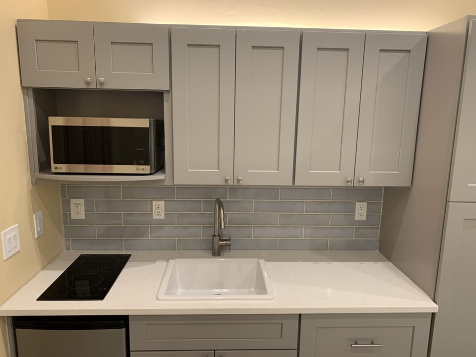 Kitchenette with microwave and plentiful cabinets.