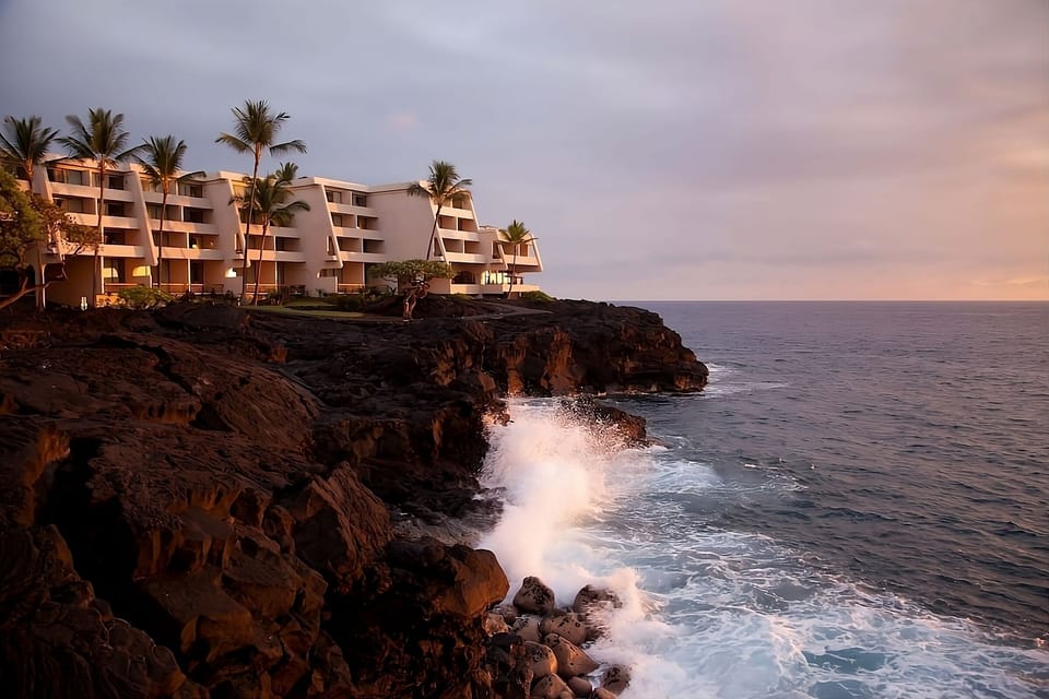 Savor sunset glow as waves crash below oceanfront balconies.