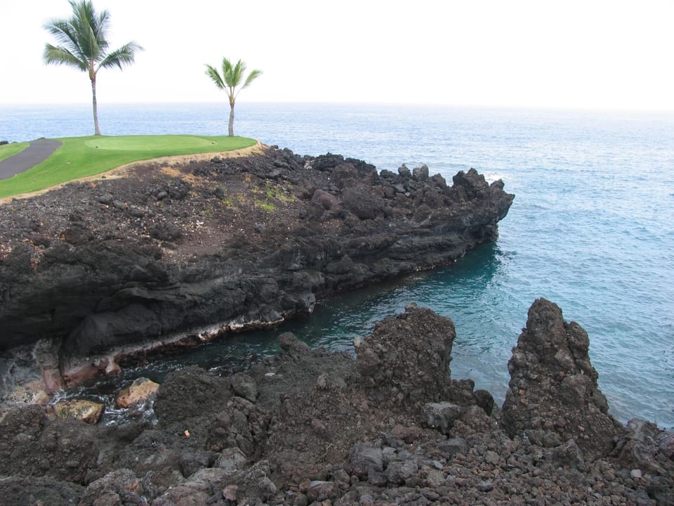 Stroll beneath swaying palms to soft sand and surf.