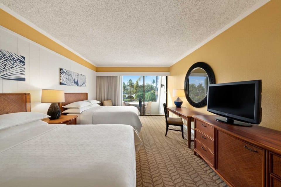 Enjoy a spacious bedroom layout with desk and balcony beyond.