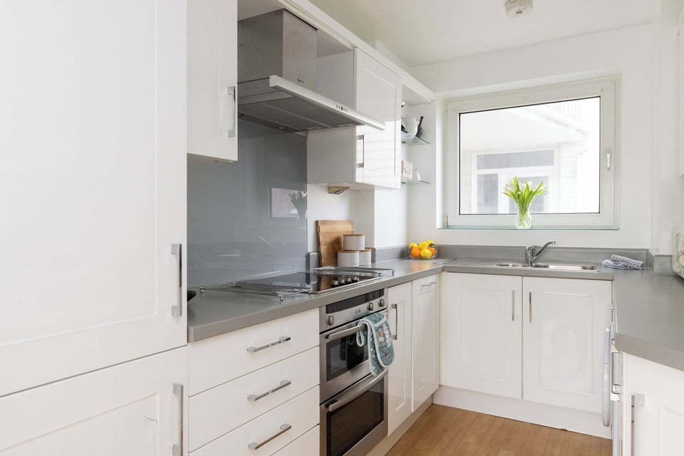 Modern fully equipped kitchen with sleek cabinetry and quality appliances, perfect for preparing home-cooked meals and beach picnics.