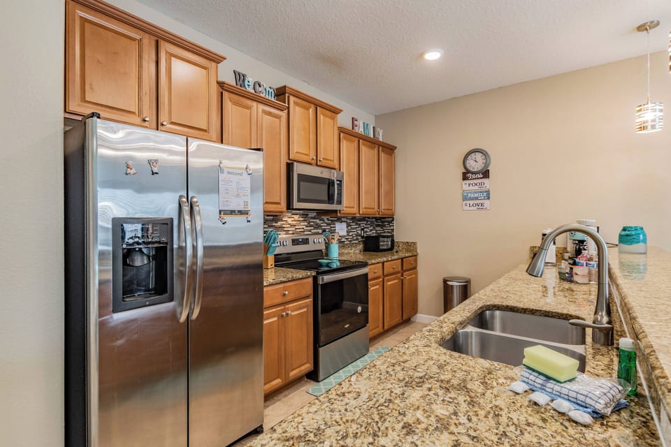 Experience the essence of this home with warm wood cabinetry and sleek stainless steel appliances. The spacious granite countertop inspires culinary creativity, while the ambient lighting creates a welcoming atmosphere for all.