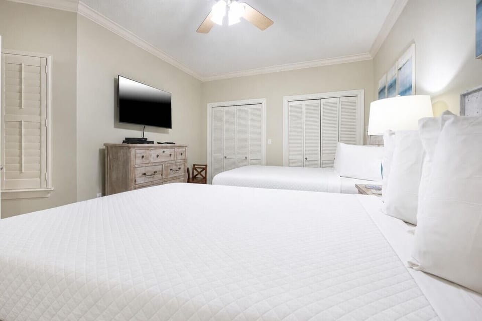 Sleep comfortably in this inviting guest room with two queen beds, a TV, and ample storage for your belongings