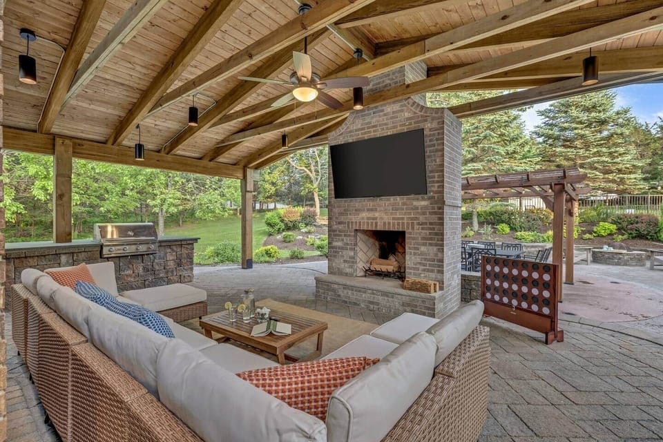 Experience the ultimate four-season hangout. An elegantly covered outdoor living area with a wood-burning fireplace, chef’s grill and kitchen, 65” TV, stylish lounge furniture, and games for all ages. 