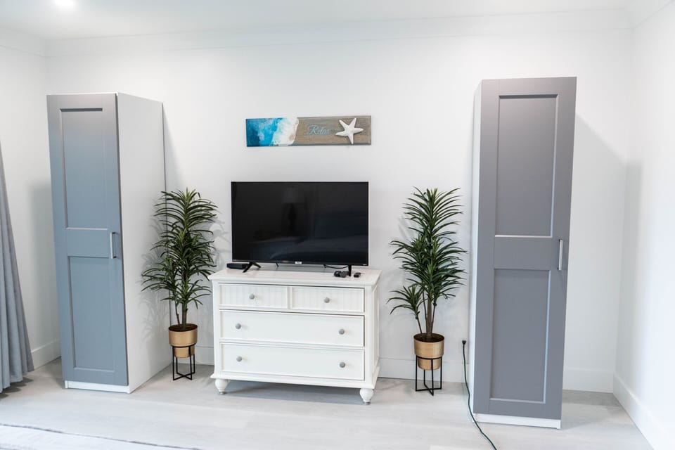 IKEA armoires, dresser and new smart TV in primary bedroom