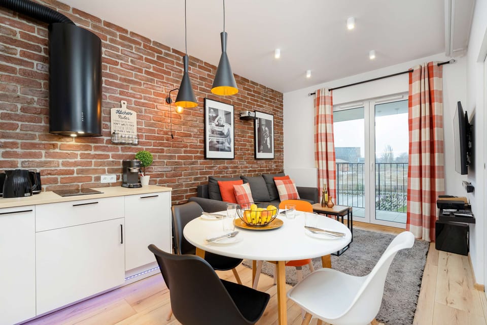 Living room with double sofa bed, TV, access to the balcony and dining area.