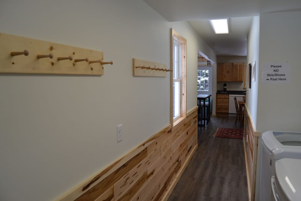 Entry way, with peg boards for coats/hats, & boot trays.