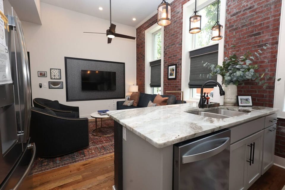 Living Room: Modern elegance with exposed brick, stylish seating, and bright views!