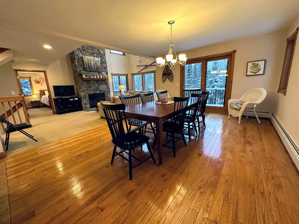 Gather around the large dining table with stunning views and direct deck access for an unforgettable dining experience.