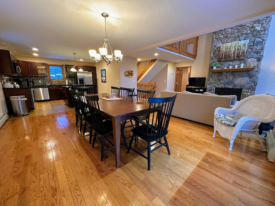 Gather around the large dining table with stunning views and direct deck access for an unforgettable dining experience.