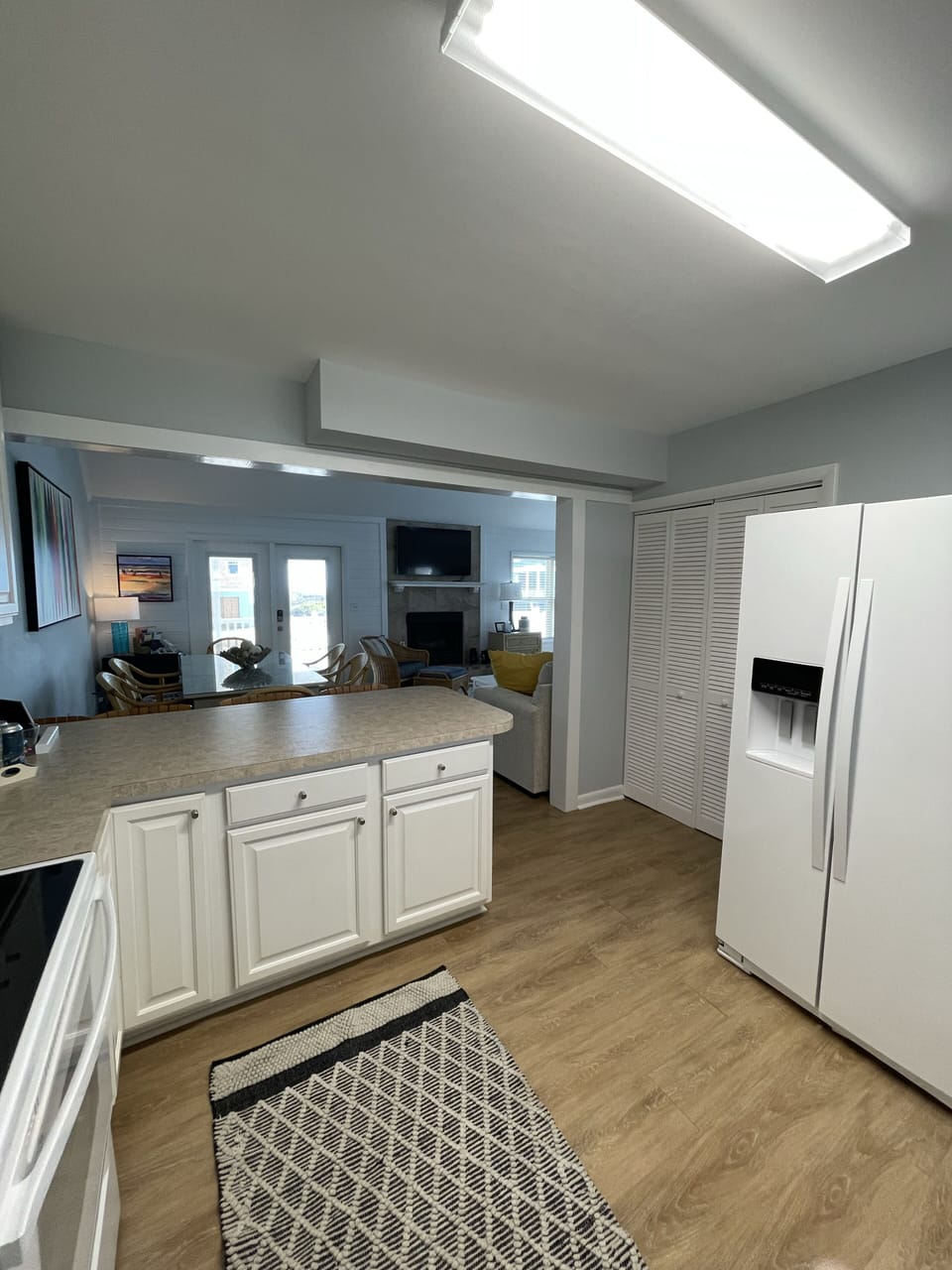 Kitchen view including appliances and 4 barstools.