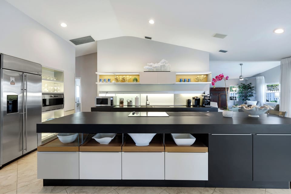 Sleek design with built-in appliances, open shelving, and a spacious island — blending function, style, and plenty of room to gather