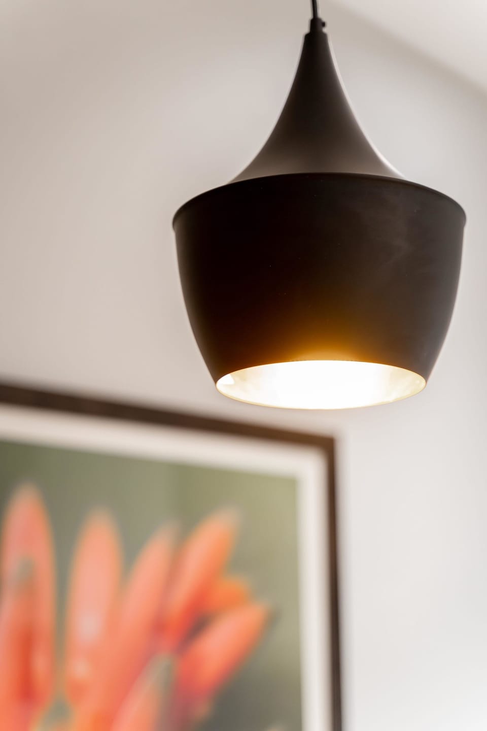 Stylish lamps hang over the sit up bar/kitchen island.