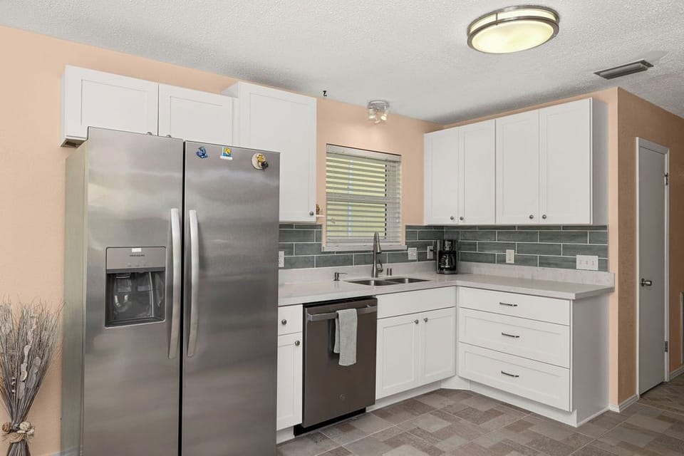 Newly remodeled kitchen with new stainless steel appliances, countertops, backslash and new tile