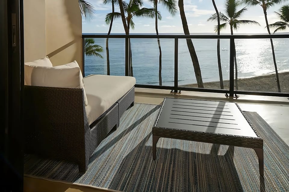 Unwind on cushioned seating with shimmering ocean sunsets.