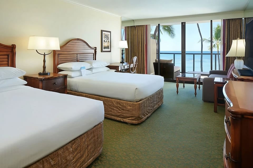 Step into a sunlit room with beds facing the ocean.
