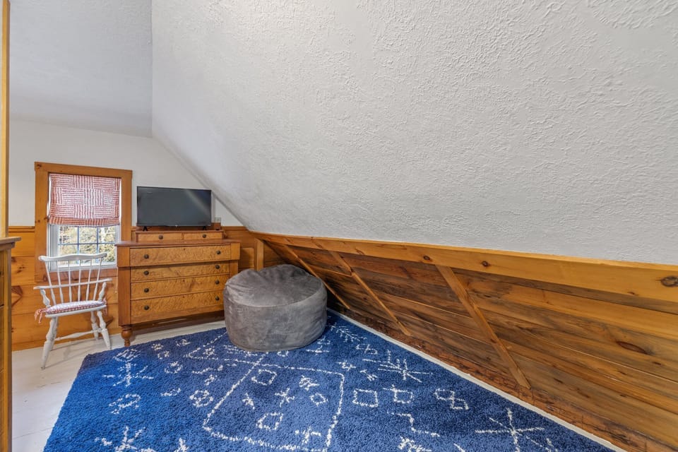 Kid's room with a trundle bed, TV, and bean bag chair