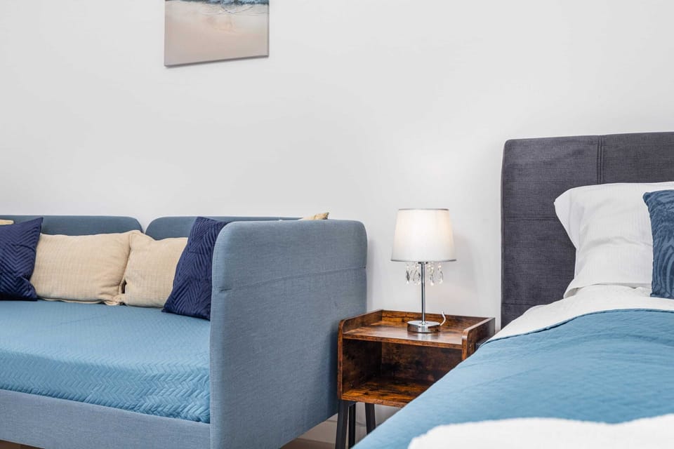 A blue sofa and matching double bed create a comfortable, stylish seating and sleeping area.