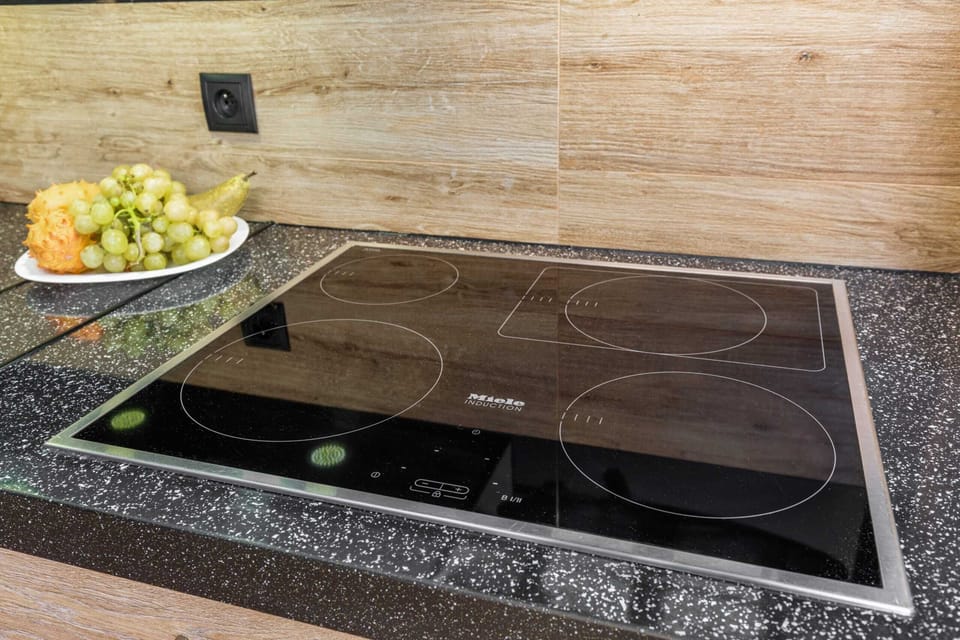 A close-up of the cooktop in the kitchenette, featuring a modern design and a smooth surface for easy cleaning. The countertop beside it provides ample space for meal preparation.