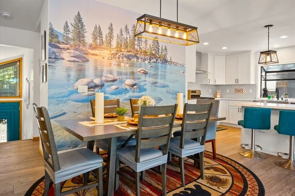 Enjoy meals together beneath modern lodge lighting with a stunning Lake Tahoe-inspired mural adding a bright mountain-lake atmosphere to every dinner.