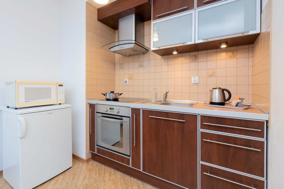 A fully equipped kitchen with a refrigerator, microwave, and cabinets for convenient meal preparation.
