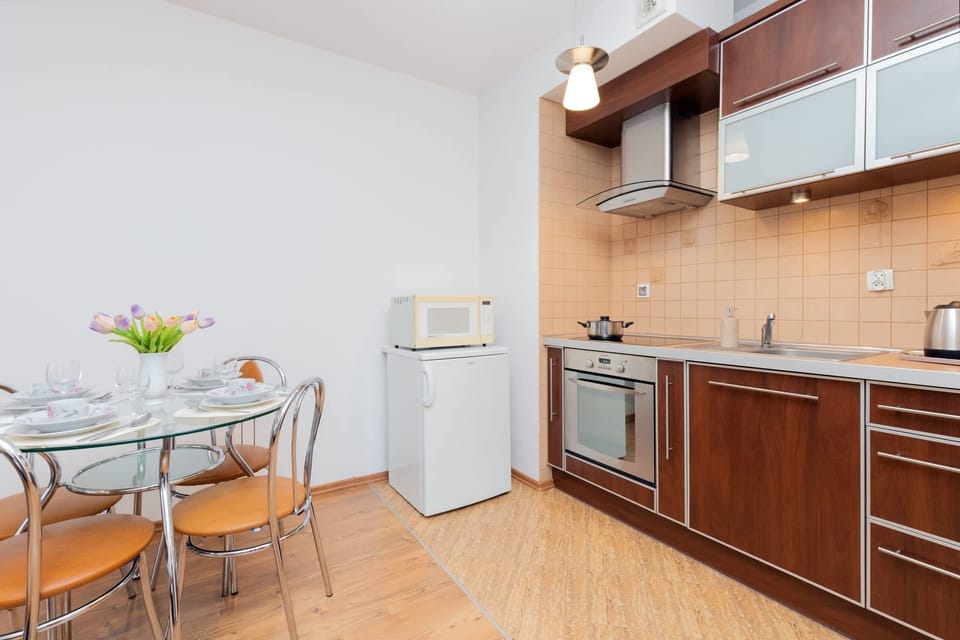 A compact kitchen equipped with wooden cabinets, a stovetop, and essential appliances.
