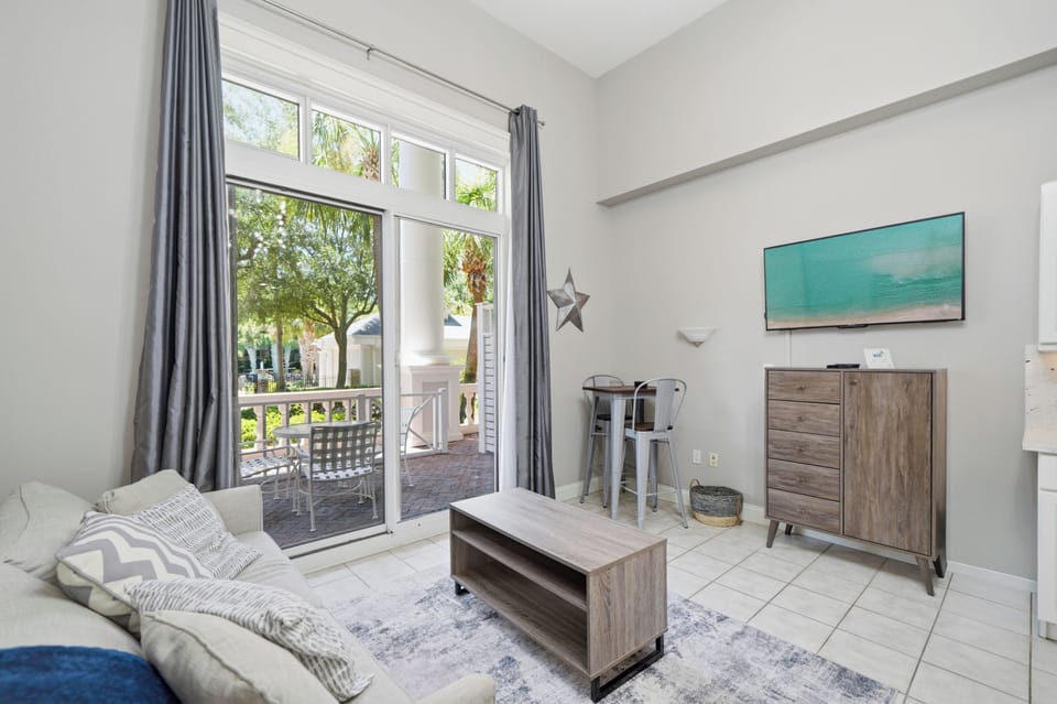 Across from the couch is a mounted flat screen TV, also visible from the bed.