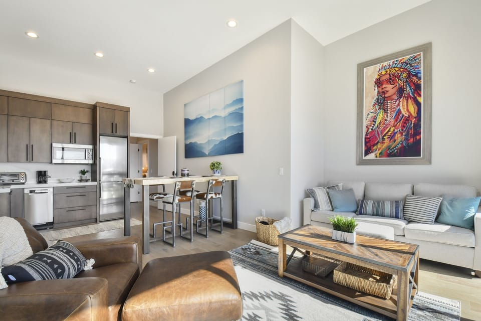 Stylish open-concept kitchen and lounge with vibrant art and natural light.