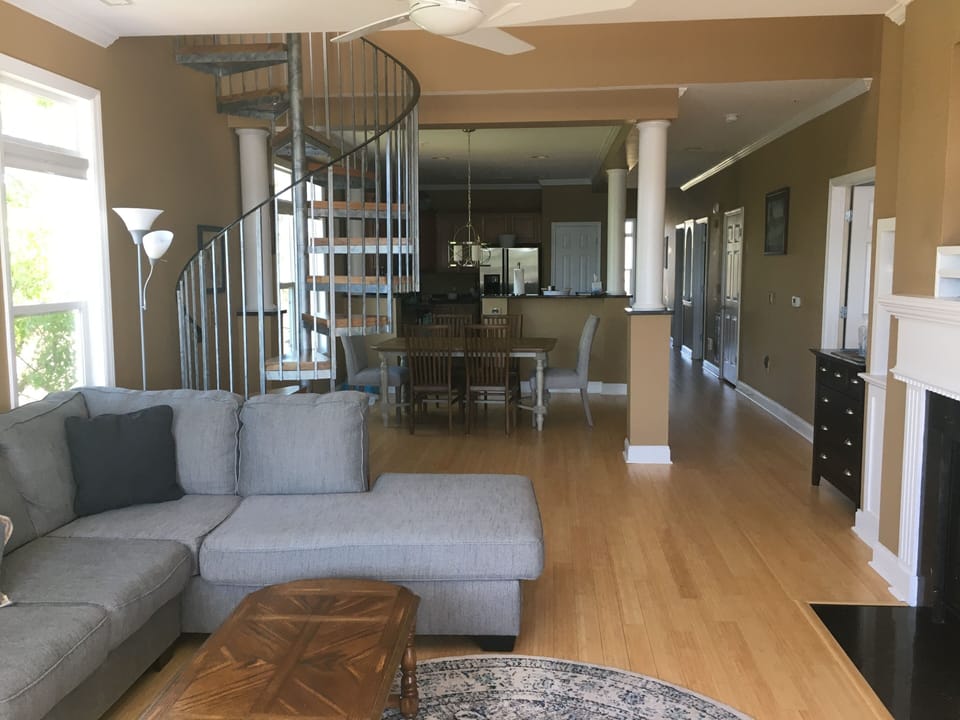 living room with spiral staircase to loft