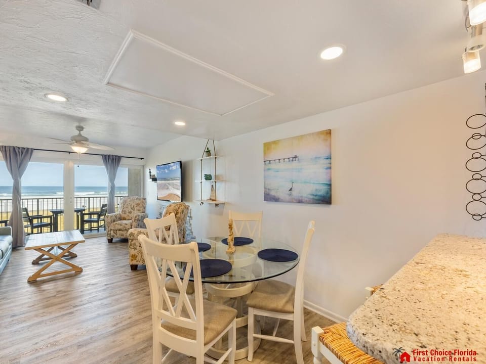 Bright and airy dining area with ocean views and cozy seating