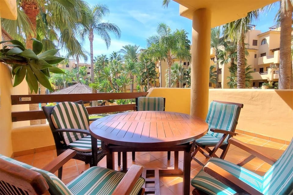 Balcony with outdoor dining area and views to the community gardens and swimming pool