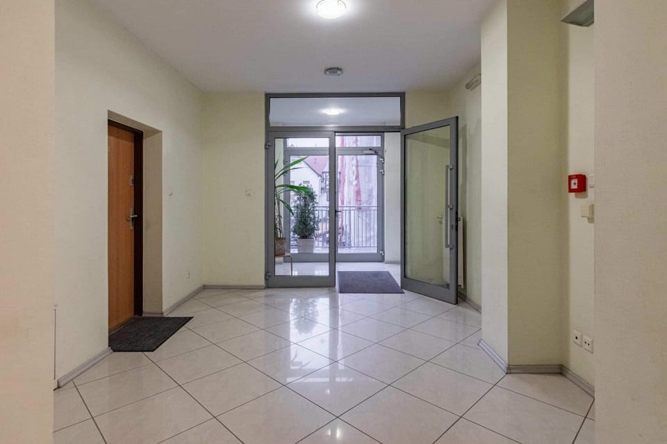 The apartment building's hallway with tiled flooring and simple decor, creating a welcoming entrance for residents and guests.