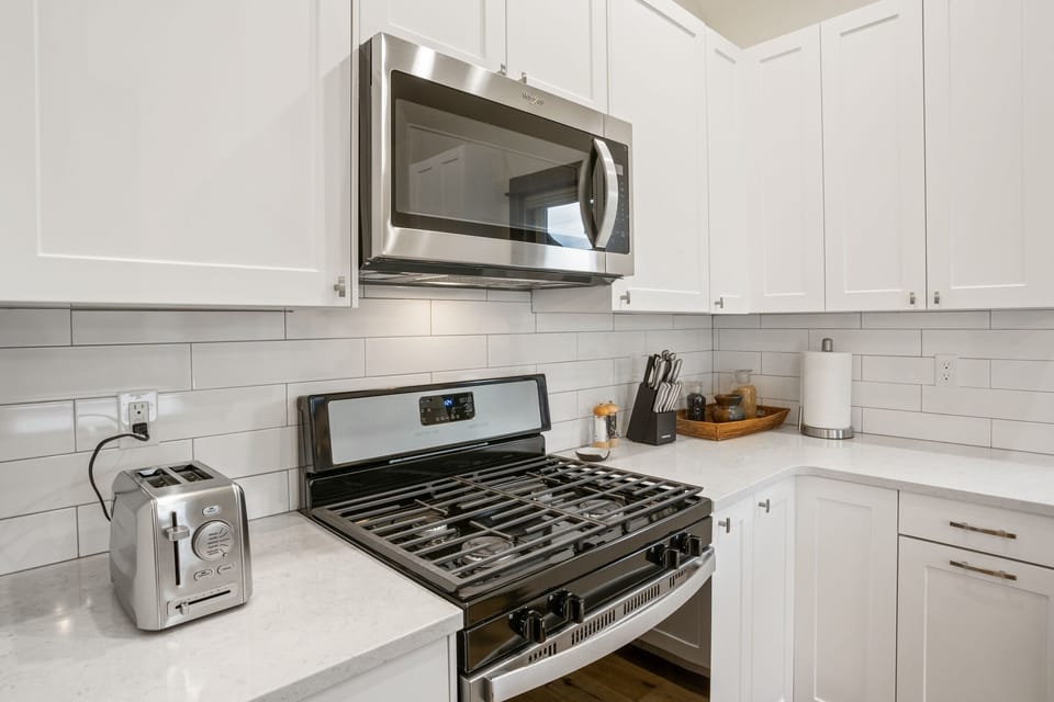 The kitchen is equipped with an electric range and oven, refrigerator, microwave, and all the necessary cookware needed.