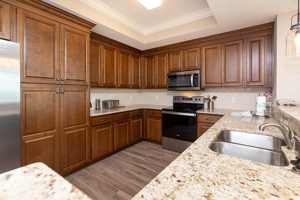 Prepare meals in this kitchen with elegant cabinetry, stainless appliances, and spacious countertops