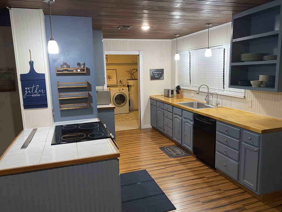 Spacious kitchen with dishes and all of the essentials for cooking.