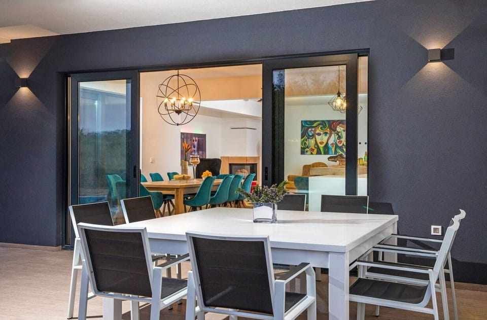 Outdoor and indoor dining table for eight people in the luxury villa Quiet Land with private pool and badminton court 