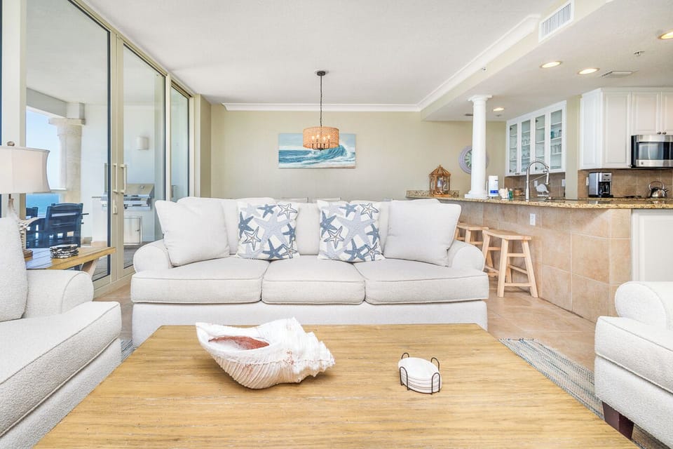 Sink into plush coastal comfort in your open-concept living space, where ocean breezes flow through and the kitchen awaits your culinary adventures.