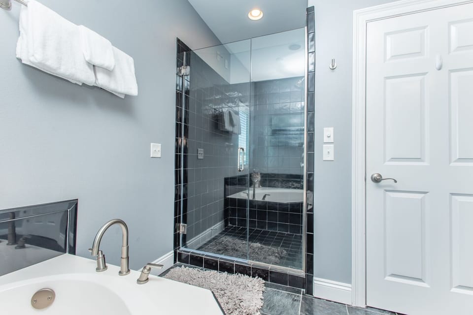 Soak in the deep tub or enjoy your private glass-enclosed shower, both perfectly framed by elegant tile and calming blue tones.
