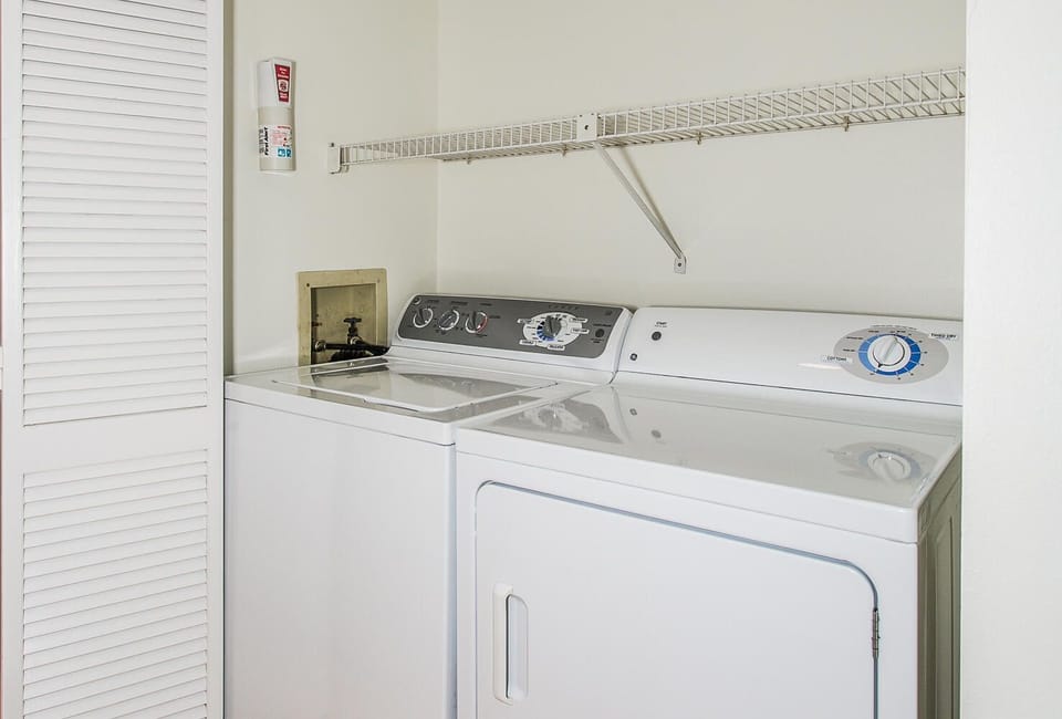 A convenient in-unit laundry area with full-size washer and dryer, plus ample storage space above for your essentials—making longer stays effortless and comfortable.