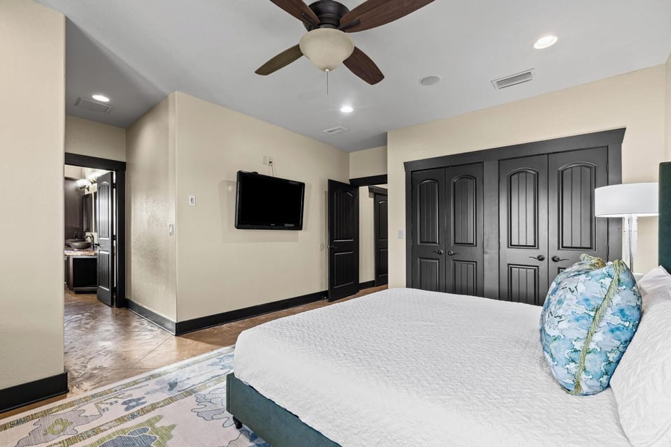 Unwind in your spacious master suite featuring elegant dark wood accents, a ceiling fan for comfort, and your own ensuite bathroom.