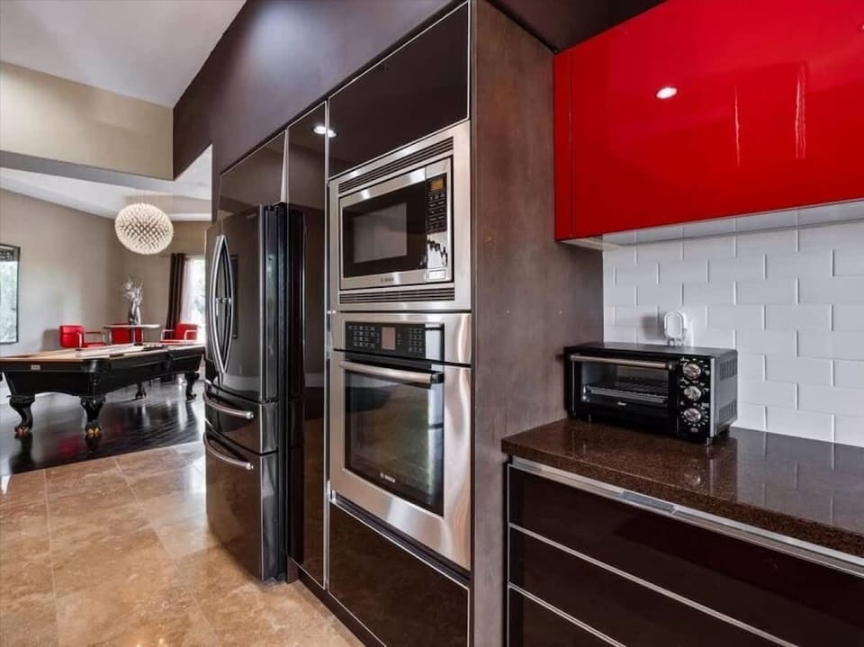Your gourmet kitchen features stainless steel appliances, bold red cabinetry, and sleek countertops—perfect for whipping up memorable meals during your stay.