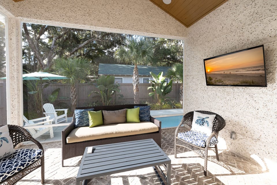Screened-in porch has a TV and comfortable seating