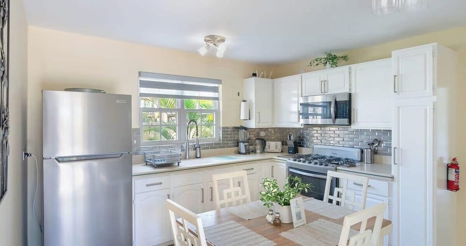 Featuring updated appliances and a cozy dining setup, this kitchen is the heart of the home.