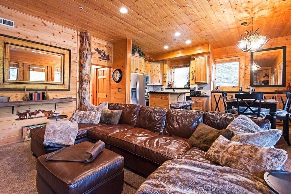 The living area, complete with a stunning river rock fireplace, large leather sectional, ottoman and flat-screen TV, places you in the center of the fun in this rustic, open space.