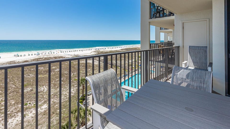 Balcony seating offers a serene view of the white sand beach and the sparkling gulf, perfect for relaxation