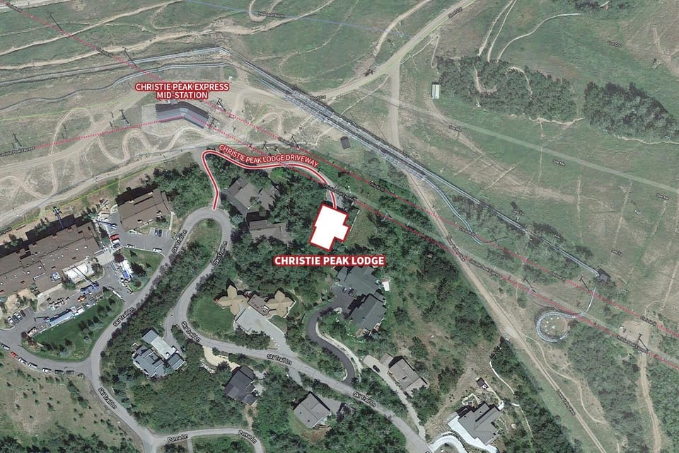 Aerial view of Christie Peak Lodge nestled among evergreen trees, with easy access to the ski express mid-station.