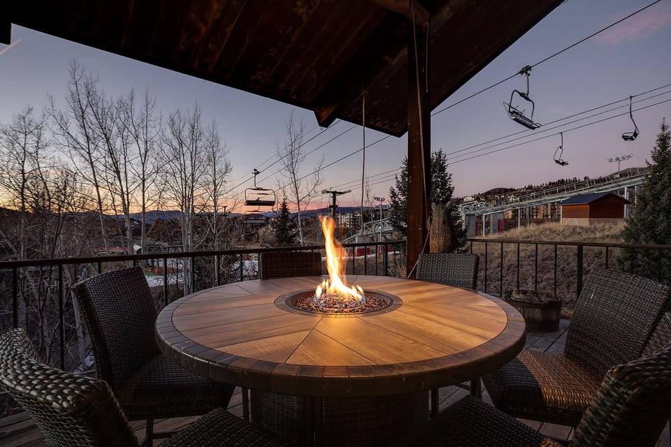 Watch the sunset glow while gathering around this cozy fire table on your covered terrace, with ski lifts visible in the distance.