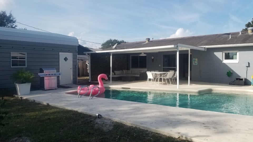 Pool deck with covered patio area and grassy area for play